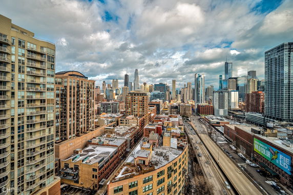 Panoramic view of a cityscape with tall buildings and a highway.