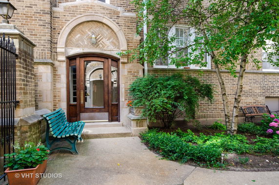 Front view of a brick building entrance with wooden door.
