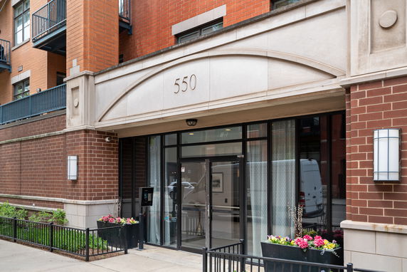 Front view of a building with red brick exterior and glass entrance doors.