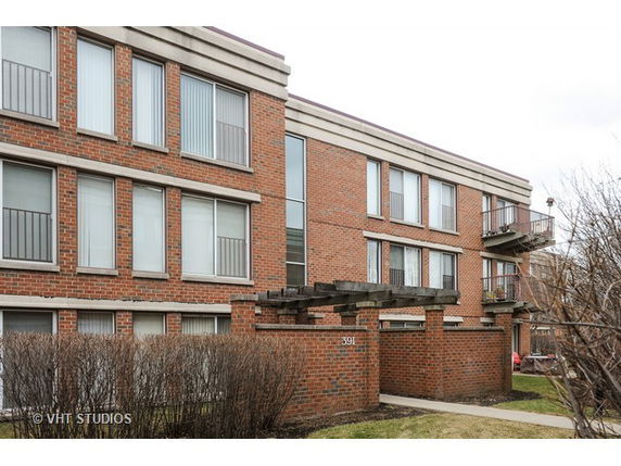 Front view of a brick apartment building with multiple balconies.