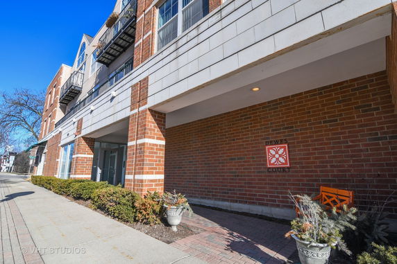 Front view of a brick building with balconies and signage.