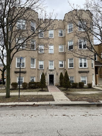 Front view of a multi-story apartment building with brick exterior.