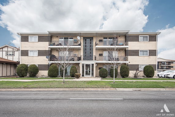Front view of a multi-story apartment building with balconies.