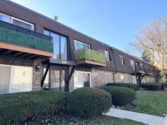 Front view of a two-story apartment building with balconies.