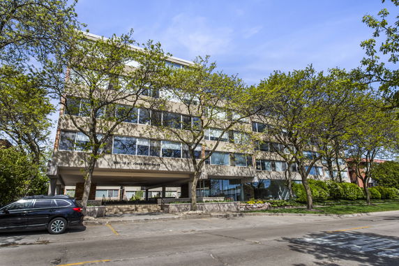 Front view of a multi-story building with large windows.