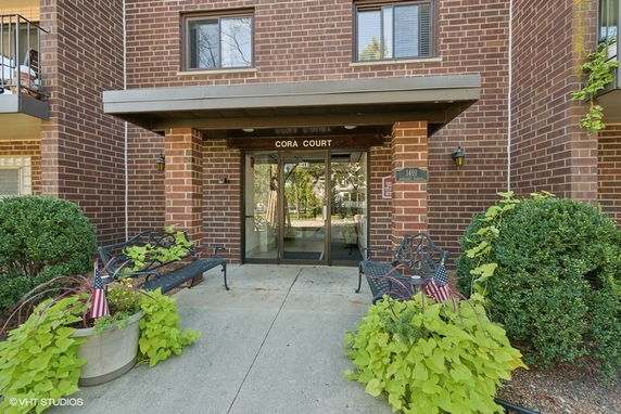 Front view of a brick residential building with glass entrance.