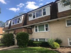 Front view of a multi-story residential building with brick and siding exterior.