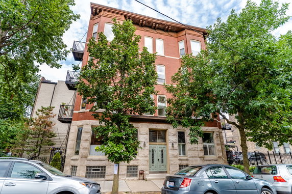 Front view of a multi-story brick building with balconies.