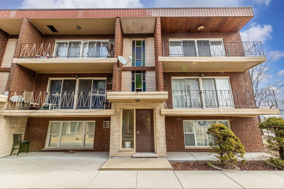 Front view of a multi-story building with balconies.