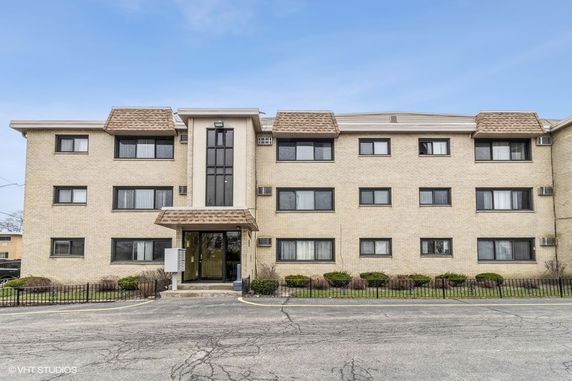 Front view of a three-story apartment building with a central entrance.