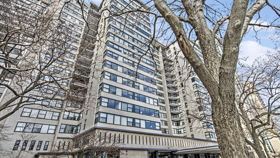 Front view of a tall residential building with balconies.