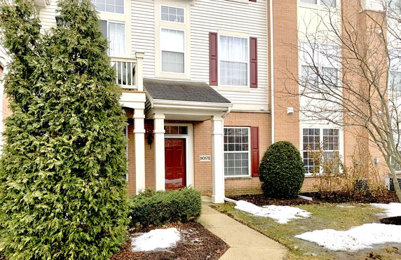 Front view of a house with red door and brick exterior.