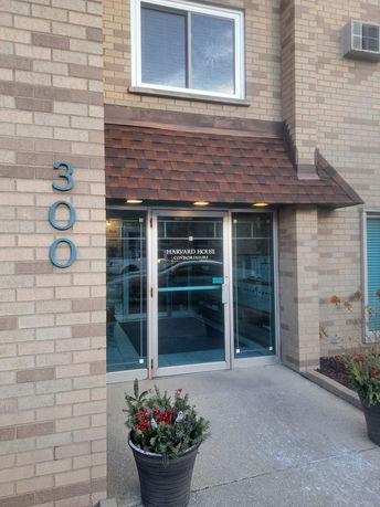 Front view of a building entrance with a brick exterior and a canopy over the doorway.