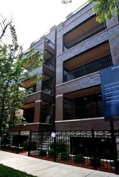 Front view of a multi-story apartment building with balconies.