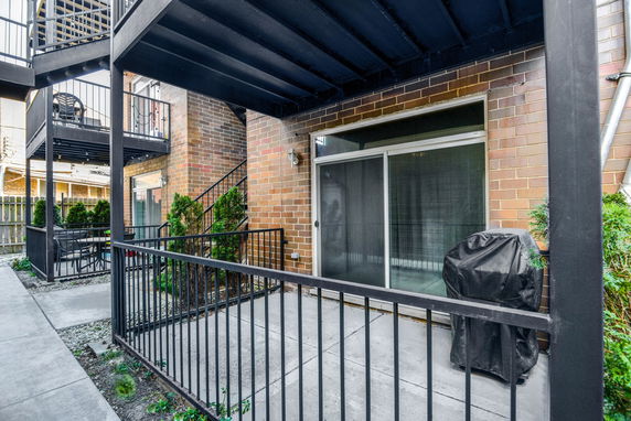 View of a brick apartment building showing balconies and patio doors.