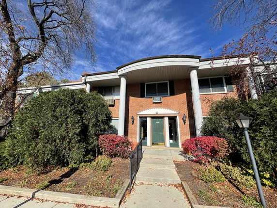 Front view of a two-story building with brick exterior and columns.