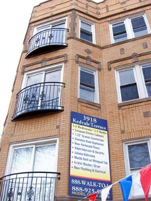 Front view of a multi-story brick building with balconies.
