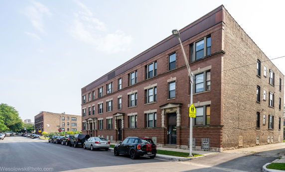 Front view of a three-story brick building with multiple windows and entrances.
