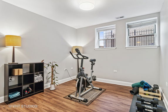 Indoor exercise room with an exercise bike, weights, and yoga mats.