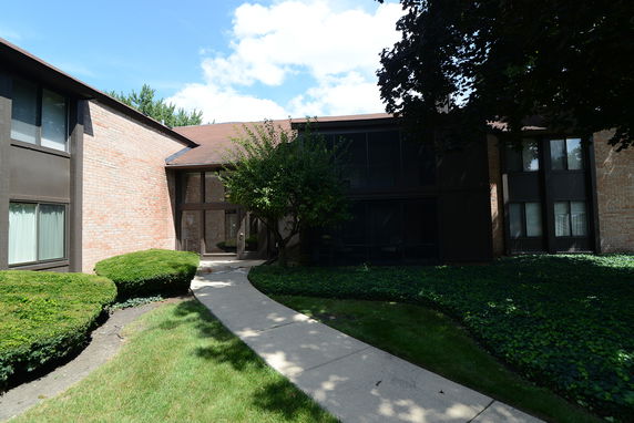 Front view of a two-story building with a brick exterior and large windows.