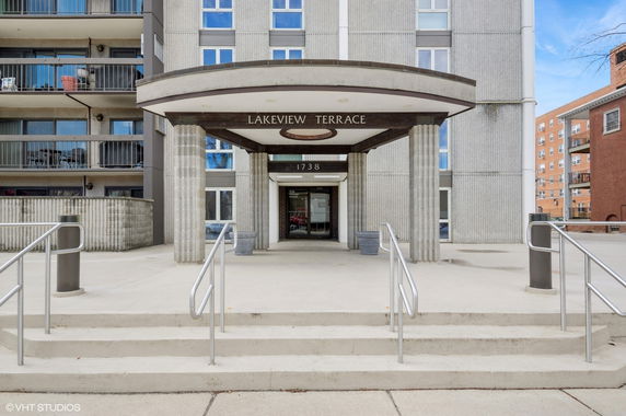 Front view of a multi-story building with balconies and an entrance canopy.