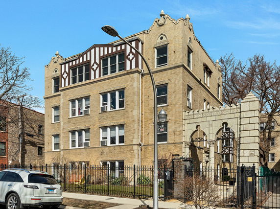 Front view of a multi-story brick building with decorative architectural details.