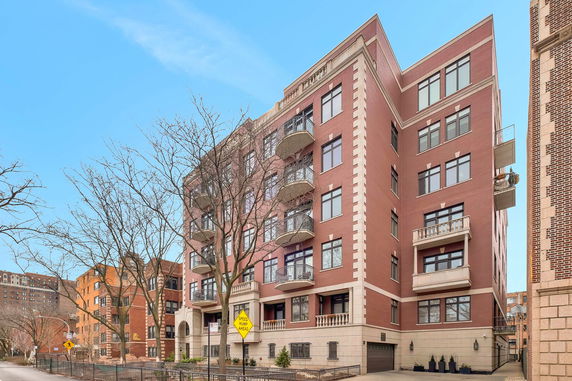 Front view of a multi-story brick apartment building with balconies.