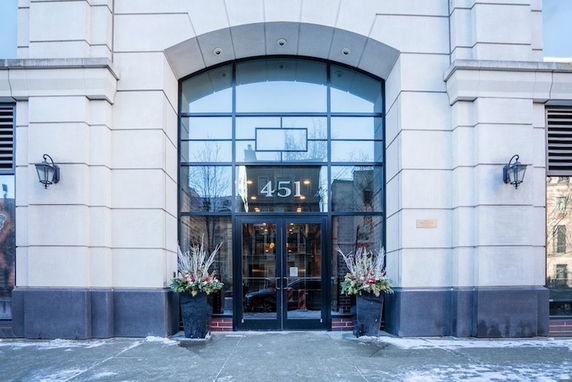 Front view of a building with large glass entrance and decorative planters.