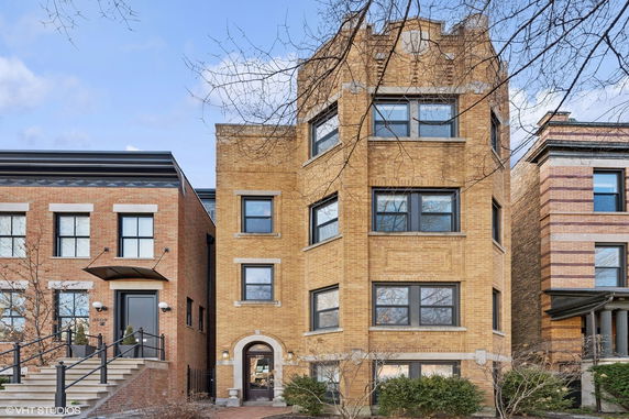 Front view of a multi-story brick building with multiple windows.