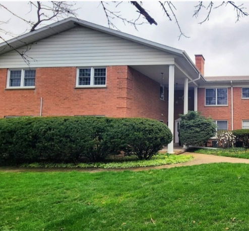 Front view of a two-story brick house with pillars.