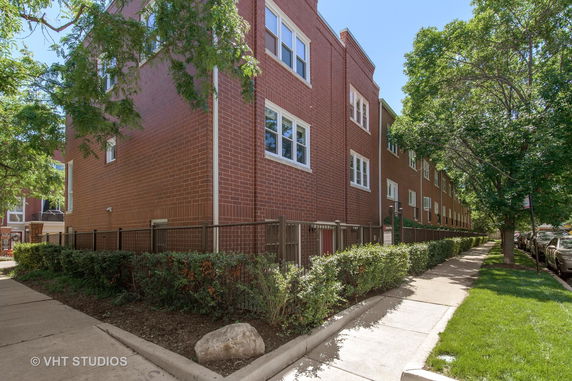 Side view of a red brick multi-story building with white-framed windows.