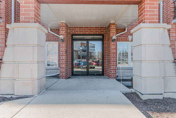 Front view of a building entrance with brick and stone columns.