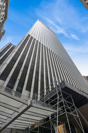 Upward view of a tall skyscraper with vertical lines.