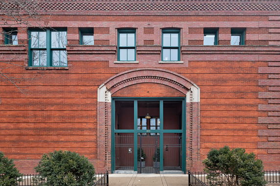 Front view of a building with a brick facade and multiple windows.