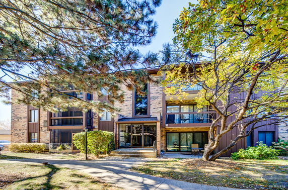 Front view of a multi-story building with balconies and brick facade.