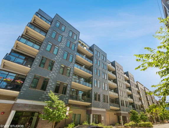 Front view of a modern multi-story apartment building with balconies.