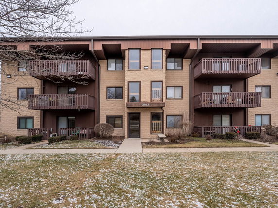 Front view of a three-story apartment building with balconies.