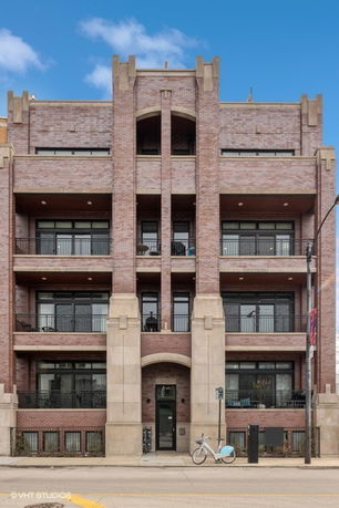 Front view of a multi-story brick building with balconies.