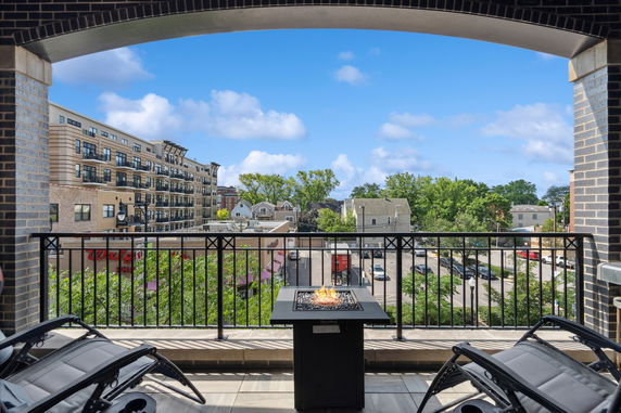 View from a balcony showing surrounding buildings and trees.
