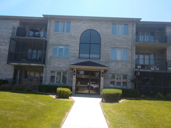 Front view of a three-story apartment building with balconies.