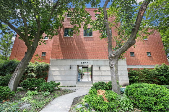 Front view of a red brick building with a gated entrance.