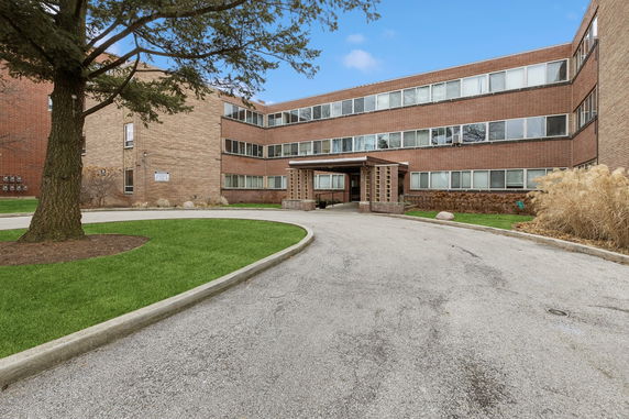 Front view of a multi-story brick building with a central entrance.