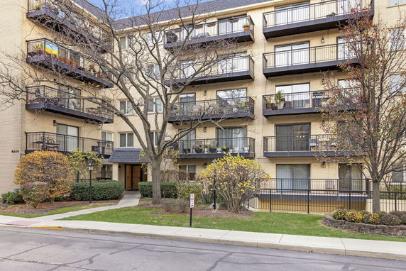 Front view of a multi-story apartment building with balconies.