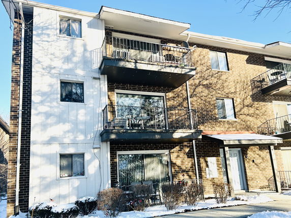 Front view of a multi-story apartment building with balconies.