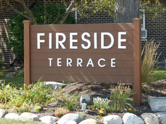 Sign reading 'Fireside Terrace' with a landscaped border.