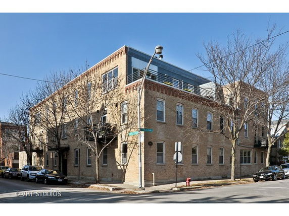 Front view of a two-story brick building on a street corner.