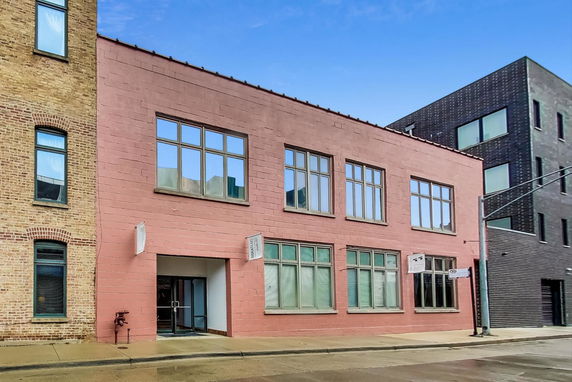 Front view of a two-story building with large windows and a red facade.