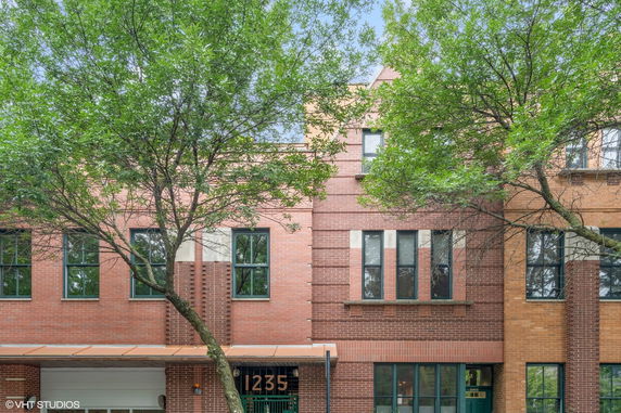 Front view of a brick building with large windows and a canopy entrance.