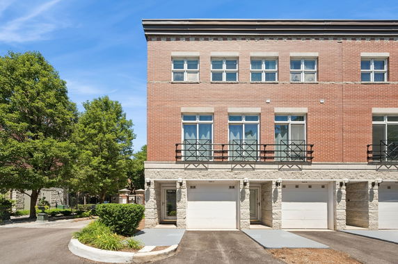 Front view of a multi-story building with brick facade and garages.