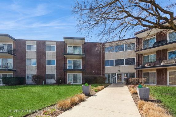 Front view of a multi-story apartment building with balconies.